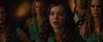 Movie still from “Whip It” (2009), directed by Drew Barrymore – A woman in a green shirt is looking at the camera; Close Up shot, Over the shoulder angle