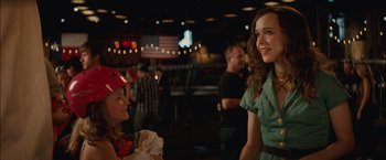 Movie still from “Whip It” (2009), directed by Drew Barrymore – A woman standing next to another woman in a green dress; Close Up shot, Over the shoulder angle