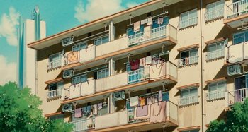 Movie still from “Whisper of the Heart” (1995), directed by Yoshifumi Kondô – A building that has a bunch of clothes hanging on it; Extreme Wide shot, Low angle