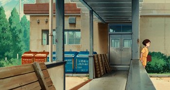 Movie still from “Whisper of the Heart” (1995), directed by Yoshifumi Kondô – A painting of a building with a lot of boxes on the ground; Extreme Wide shot, Low angle