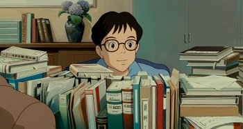 Movie still from “Whisper of the Heart” (1995), directed by Yoshifumi Kondô – A boy sitting in front of a pile of books; Medium shot, High angle