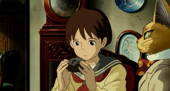 Movie still from “Whisper of the Heart” (1995), directed by Yoshifumi Kondô – A young boy holding a camera in front of a clock tower; Close Up shot, High angle