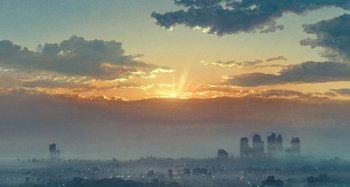 Movie still from “Whisper of the Heart” (1995), directed by Yoshifumi Kondô – The sun is setting over a city skyline; Extreme Wide shot, Low angle