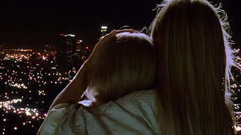 Movie still from “White Oleander” (2002), directed by Peter Kosminsky – A woman with long blonde hair is looking out at the city; Close Up shot, High angle
