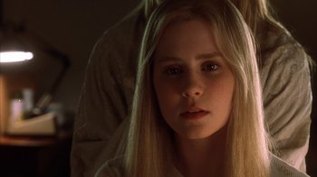 Movie still from “White Oleander” (2002), directed by Peter Kosminsky – A young blonde woman with long hair looking at the camera; Close Up shot, Low angle