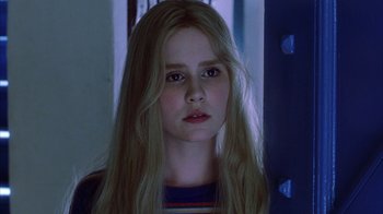 Movie still from “White Oleander” (2002), directed by Peter Kosminsky – A girl with long blonde hair is looking at the camera; Close Up shot, Low angle
