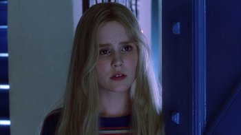 Movie still from “White Oleander” (2002), directed by Peter Kosminsky – A girl with long blonde hair stares into the camera; Close Up shot, Low angle