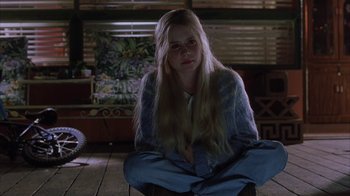Movie still from “White Oleander” (2002), directed by Peter Kosminsky – A woman sitting on the ground in a room; Medium shot, High angle