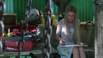 Movie still from “White Oleander” (2002), directed by Peter Kosminsky – A woman sitting on a bench writing on a piece of paper; Medium shot, Over the shoulder angle