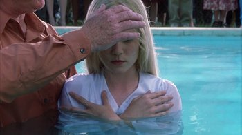 Movie still from “White Oleander” (2002), directed by Peter Kosminsky – A woman being baptised in a body of water; Close Up shot, High angle