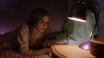 Movie still from “White Oleander” (2002), directed by Peter Kosminsky – A woman is reading a book in the dark; Close Up shot, High angle