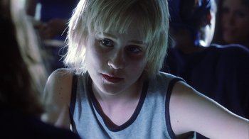 Movie still from “White Oleander” (2002), directed by Peter Kosminsky – A young girl with blonde hair looking at the camera; Close Up shot, Over the shoulder angle