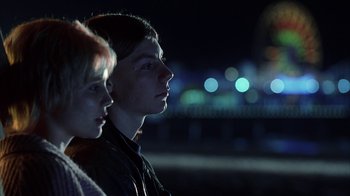 Movie still from “White Oleander” (2002), directed by Peter Kosminsky – A man and a woman are standing in front of a bridge at night; Medium shot, Low angle