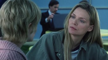 Movie still from “White Oleander” (2002), directed by Peter Kosminsky – A woman and a boy are talking to each other in front of a man; Close Up shot, Over the shoulder angle