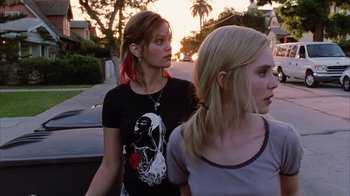 Movie still from “White Oleander” (2002), directed by Peter Kosminsky – Two young women walking down a street in a neighborhood; Close Up shot, Low angle