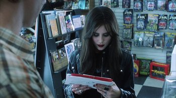 Movie still from “White Oleander” (2002), directed by Peter Kosminsky – A woman is looking down at a book; Medium shot, Over the shoulder angle