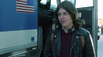 Movie still from “White Oleander” (2002), directed by Peter Kosminsky – A young man standing on the side of a bus; Close Up shot, Low angle
