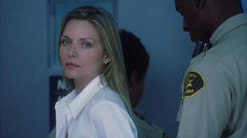 Movie still from “White Oleander” (2002), directed by Peter Kosminsky – A woman in a white shirt is looking at the camera; Close Up shot, Over the shoulder angle
