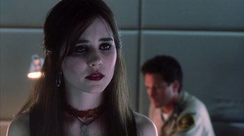 Movie still from “White Oleander” (2002), directed by Peter Kosminsky – A young woman with dark hair wearing a red necklace; Close Up shot, Over the shoulder angle