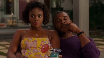 Movie still from “Why Did I Get Married Too?” (2010), directed by Tyler Perry – A man and a woman sitting next to each other on a couch; Medium shot, Over the shoulder angle