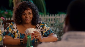 Movie still from “Why Did I Get Married Too?” (2010), directed by Tyler Perry – A woman sitting at a table holding a bunch of cards; Medium shot, Over the shoulder angle