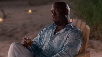 Movie still from “Why Did I Get Married Too?” (2010), directed by Tyler Perry – A man sitting in a chair holding a glass of wine; Medium shot, High angle