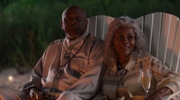 Movie still from “Why Did I Get Married Too?” (2010), directed by Tyler Perry – An older man and woman sitting on a chair; Medium shot, Low angle