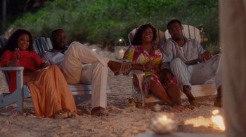 Movie still from “Why Did I Get Married Too?” (2010), directed by Tyler Perry – A group of people sitting on top of a beach; Wide shot, High angle
