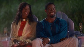 Movie still from “Why Did I Get Married Too?” (2010), directed by Tyler Perry – A man and a woman sitting on a lawn chair; Medium shot, High angle