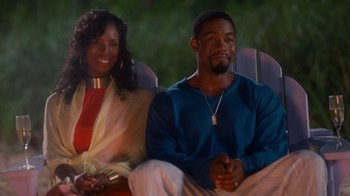 Movie still from “Why Did I Get Married Too?” (2010), directed by Tyler Perry – A man and a woman sitting on a chair; Medium shot, Over the shoulder angle