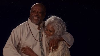 Movie still from “Why Did I Get Married Too?” (2010), directed by Tyler Perry – An older man and a younger woman are hugging; Medium shot, Low angle