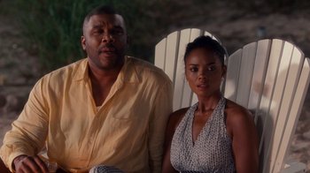 Movie still from “Why Did I Get Married Too?” (2010), directed by Tyler Perry – A man and a woman sitting next to each other on a chair; Medium shot, Over the shoulder angle