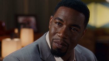 Movie still from “Why Did I Get Married Too?” (2010), directed by Tyler Perry – A person wearing a suit and tie; Close Up shot, Over the shoulder angle