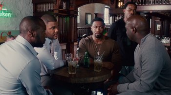 Movie still from “Why Did I Get Married Too?” (2010), directed by Tyler Perry – A group of men sitting around a table with drinks; Medium shot, Over the shoulder angle
