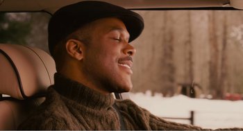 Movie still from “Why Did I Get Married?” (2007), directed by Tyler Perry – A man in a hat is sitting in a car; Close Up shot, Low angle