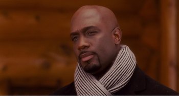Movie still from “Why Did I Get Married?” (2007), directed by Tyler Perry – A bald man with a scarf and a black jacket; Close Up shot, Low angle