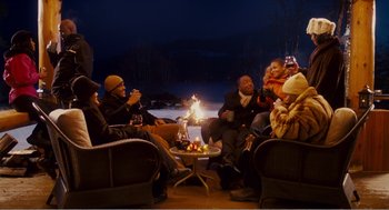 Movie still from “Why Did I Get Married?” (2007), directed by Tyler Perry – A group of people sitting around a fire pit at night; Wide shot, High angle