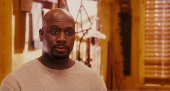 Movie still from “Why Did I Get Married?” (2007), directed by Tyler Perry – A man with a bald head is looking at the camera; Close Up shot, High angle
