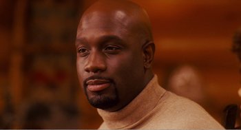 Movie still from “Why Did I Get Married?” (2007), directed by Tyler Perry – A man with a bald head wearing a tan sweater; Close Up shot, Low angle