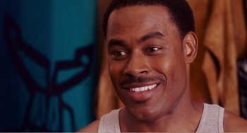 Movie still from “Why Did I Get Married?” (2007), directed by Tyler Perry – A person with a beard smiling; Close Up shot, Over the shoulder angle