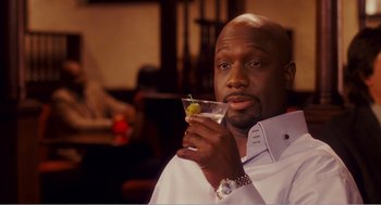 Movie still from “Why Did I Get Married?” (2007), directed by Tyler Perry – A man holding a glass with a drink in his hand; Close Up shot, High angle