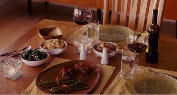 Movie still from “Why Did I Get Married?” (2007), directed by Tyler Perry – A wooden table topped with plates of food and glasses of water; Medium shot, High angle