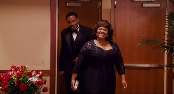 Movie still from “Why Did I Get Married?” (2007), directed by Tyler Perry – A man and a woman in formal wear walking down a hall way; Medium shot, Over the shoulder angle