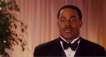 Movie still from “Why Did I Get Married?” (2007), directed by Tyler Perry – A man wearing a tuxedo and a bow tie; Close Up shot, Over the shoulder angle