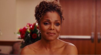Movie still from “Why Did I Get Married?” (2007), directed by Tyler Perry – A woman in a strapless dress with a flower in her hair; Close Up shot, Over the shoulder angle
