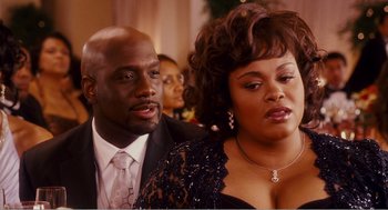 Movie still from “Why Did I Get Married?” (2007), directed by Tyler Perry – A man and a woman in formal wear looking at the camera; Close Up shot, Over the shoulder angle