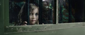 Movie still from “Wildling” (2018), directed by Fritz Böhm – A little girl looking out of a window; Extreme Close Up shot, High angle