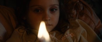 Movie still from “Wildling” (2018), directed by Fritz Böhm – A little girl is looking at a lit candle; Close Up shot, High angle