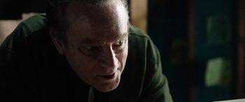 Movie still from “Wildling” (2018), directed by Fritz Böhm – An older man looking down at the ground; Close Up shot, Over the shoulder angle