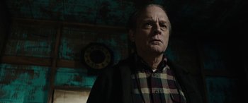 Movie still from “Wildling” (2018), directed by Fritz Böhm – An older man standing in front of a wall clock; Close Up shot, Low angle